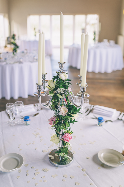 Candelabra display with roses and ranunculus woven in