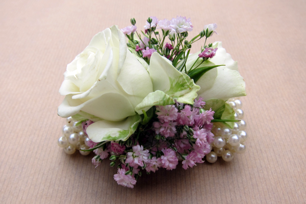 Wedding wrist corsage featuring roses and gypsophila