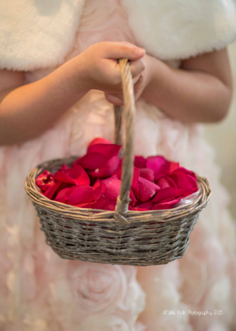 Bright pink rose petal confetti in a wicker basket. Floral design by Cotswold Blooms, wedding florist based in Cheltenham.