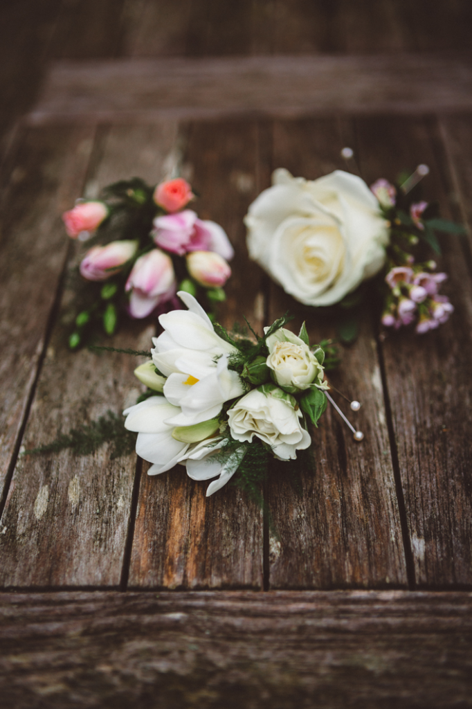 Floral buttonholes combining spray roses and freesia
