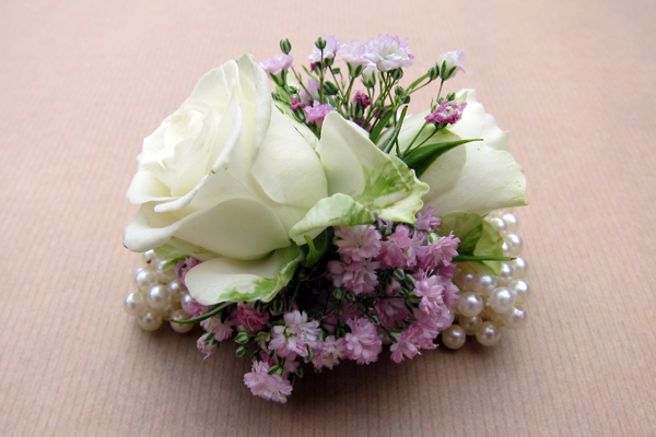 Pearl bracelet wrist corsage with roses and pink gypsophila. Floral design by Cotswold Blooms, wedding florist based in Cheltenham.