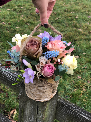 Flower girl basket in a rustic bucket in pastel shades. Floral design by Cotswold Blooms, wedding florist based in Cheltenham.