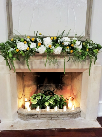 Mantel piece display in lime greens, white and yellow including Amaranthus, Hydrangea, Roses, and Stocks at Foxhill Manor. Floral design by Cotswold Blooms, wedding florist based in Cheltenham.