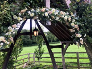 Natural arch display at Hyde House in white and nude pinks including Dahlia, Eustoma, Stocks with mixed Eucalyptus. Floral design by Cotswold Blooms, wedding florist based in Cheltenham.