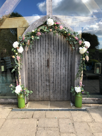 Silver birch arch display with Hydrangea, Astilbe, Roses and Mixed foliage at Cripps Barn. Floral design by Cotswold Blooms, wedding florist based in Cheltenham.