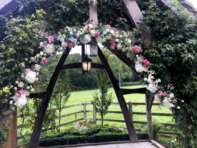 Natural arch display in pinks and white including Hydrangea, Roses, Waxflower and Eustoma. Floral design by Cotswold Blooms, wedding florist based in Cheltenham.
