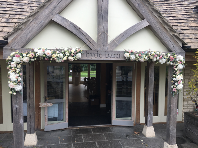 Pastel pinks and white around the entrance at Hyde House including Roses, Hydrangea, Eustoma and Waxflower. Floral design by Cotswold Blooms, wedding florist based in Cheltenham.