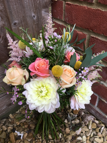 Coral, peach and light pink natural brides bouquet. Floral design by Cotswold Blooms, wedding florist based in Cheltenham.