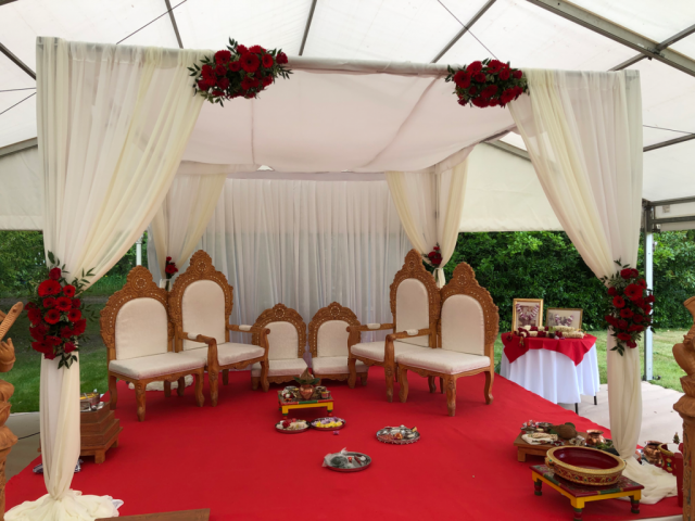Mandap display in red and green with Roses, and Gerbera at Manor by the Lake. Floral design by Cotswold Blooms, wedding florist based in Cheltenham.