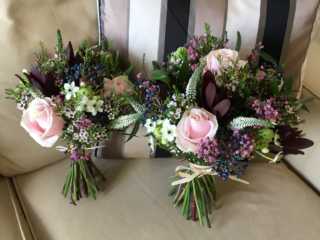 Country garden hand tied bouquets with Heather, Waxflower, Viburnum, Safari and Roses. Floral design by Cotswold Blooms, wedding florist based in Cheltenham.