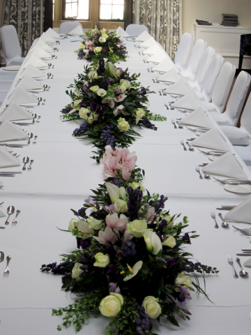 Purple, white and light pinks including Roses, Orchids, Anthurium and lush green foliage at Foxhill Manor. Floral design by Cotswold Blooms, wedding florist based in Cheltenham.