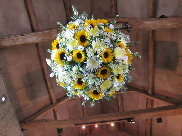 Sunflowers and white Chrysanthemum, Gypsophila, Eustoma and foliage flower ball at Cripps Barn. Floral design by Cotswold Blooms, wedding florist based in Cheltenham.