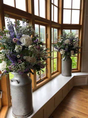 Milk churn displays in a country garden style at the Grange Hyde House. Floral design by Cotswold Blooms, wedding florist based in Cheltenham.