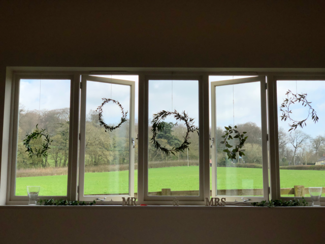 Foliage rings hanging in the window at Hyde House. Floral design by Cotswold Blooms, wedding florist based in Cheltenham.