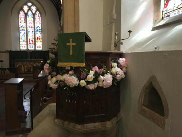Flower garland dressing the pulpit at Upper Slaughter Church. Floral design by Cotswold Blooms, wedding florist based in Cheltenham.