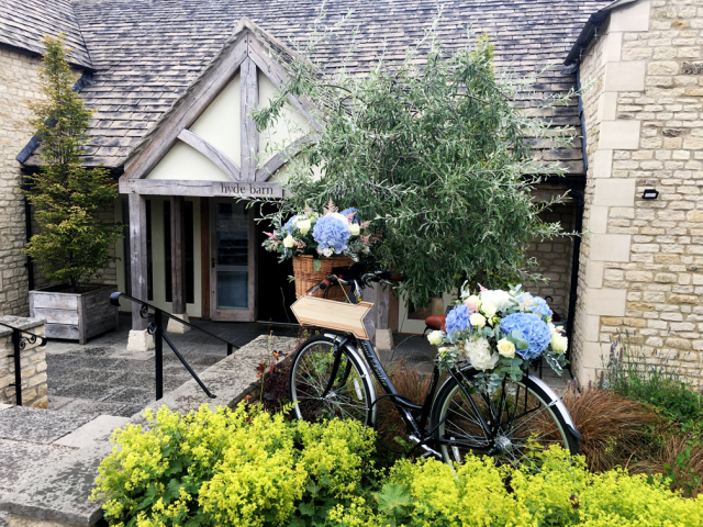 Bike entrance display at Hyde House, Stow-on-the-wold. Floral design by Cotswold Blooms, wedding florist based in Cheltenham.