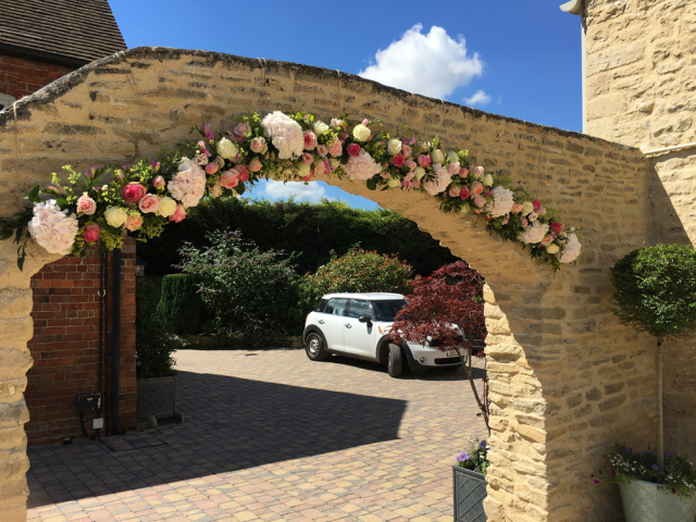 Arch display at a private house wedding in shades of pink and white. Floral design by Cotswold Blooms, wedding florist based in Cheltenham.