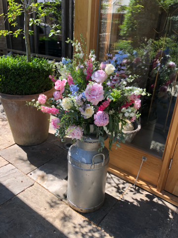 Bright pastels milk churn display at Calcot Manor. Floral design by Cotswold Blooms, wedding florist based in Cheltenham.