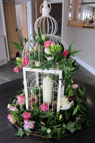 Bird cage display with foliage and flowers. Floral design by Cotswold Blooms, wedding florist based in Cheltenham.