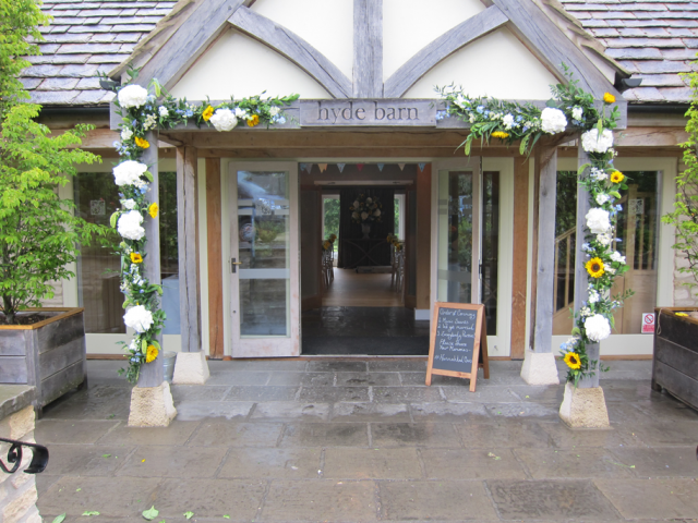 Hydrangea and Roses entrance arch at Hyde House. Floral design by Cotswold Blooms, wedding florist based in Cheltenham.