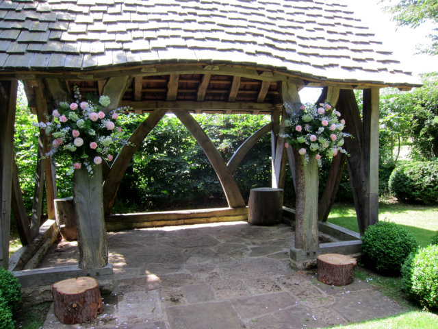Outdoor ceremony at Cripps Barn including light pink Roses, Delphinium and Cow Parsley. Floral design by Cotswold Blooms, wedding florist based in Cheltenham.