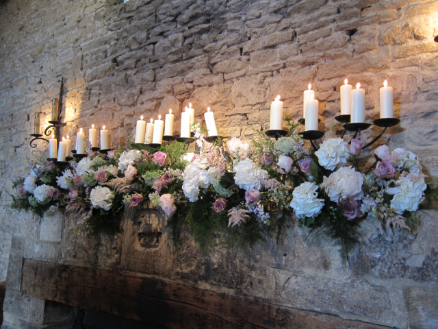 Soft pastel mantel piece display at Cripps Stone Barn. Floral design by Cotswold Blooms, wedding florist based in Cheltenham.