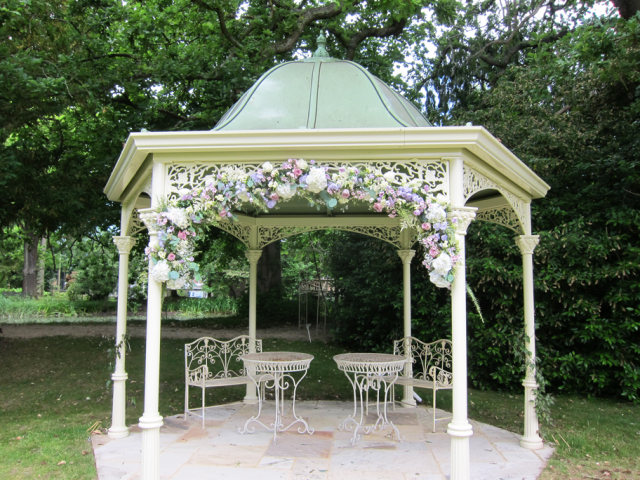Wedding arch at Manor by the Lake, in lilac and creams in a country garden style. Floral design by Cotswold Blooms, wedding florist based in Cheltenham.