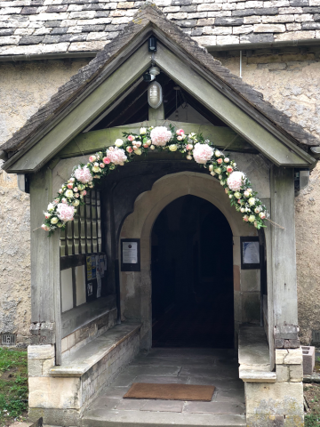 Church entrance in light pink and white. Floral design by Cotswold Blooms, wedding florist based in Cheltenham.