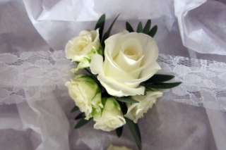 Vintage lace wrist corsage made from white Roses. Floral design by Cotswold Blooms, wedding florist based in Cheltenham.