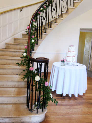 Ruscus and Rose garland display up the stairs at Eastington Park. Floral design by Cotswold Blooms, wedding florist based in Cheltenham.