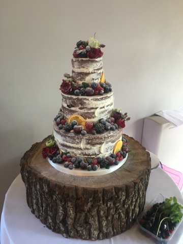 Winter naked cake with Ranunculus and Roses. Floral design by Cotswold Blooms, wedding florist based in Cheltenham.