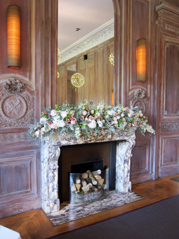 Mantel piece display in white and peach at Cowley Manor. Floral design by Cotswold Blooms, wedding florist based in Cheltenham.