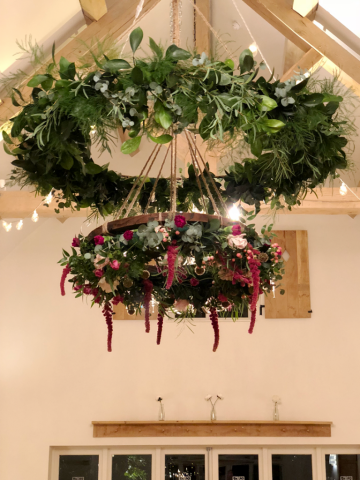 Drop halo with a foliage ring and flower wheel in raspberry and light pink. Floral design by Cotswold Blooms, wedding florist based in Cheltenham.