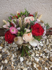 Country garden bouquet in red, peach and pink with poppy heads and wheat. Floral design by Cotswold Blooms, wedding florist based in Cheltenham.