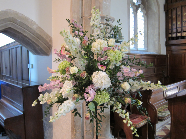 Striking church arrangement made with Hydrangea, Delphinium and Calla Lilies. Floral design by Cotswold Blooms, wedding florist based in Cheltenham.