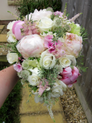 A hand tied teardrop bouquet containing Peonies, Roses, Phlox and Astrantia. Floral design by Cotswold Blooms, wedding florist based in Cheltenham.
