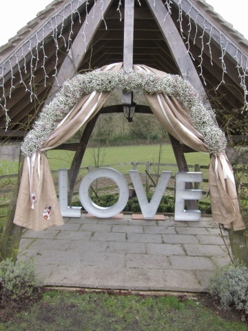 Gypsophila arch with hessian drape and ribbons. Floral design by Cotswold Blooms, wedding florist based in Cheltenham.