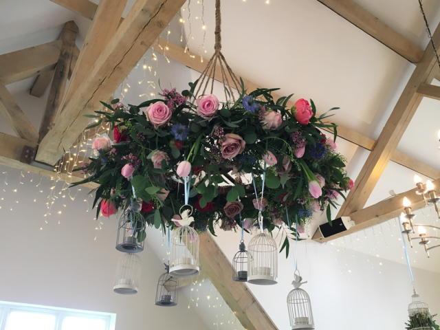 Hanging halo with bird cages with Tulips, Roses, Peonies and Waxflower. Floral design by Cotswold Blooms, wedding florist based in Cheltenham.