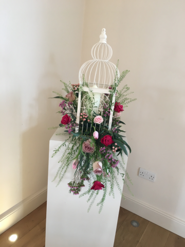 Bird cage with bright, dusky and light pink including Tulips, Roses, Peonies and Waxflower. Floral design by Cotswold Blooms, wedding florist based in Cheltenham.