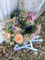 Blue Agapanthus, peach and lilac Roses, and pink Larkspur with Poppy Heads. Floral design by Cotswold Blooms, wedding florist based in Cheltenham.