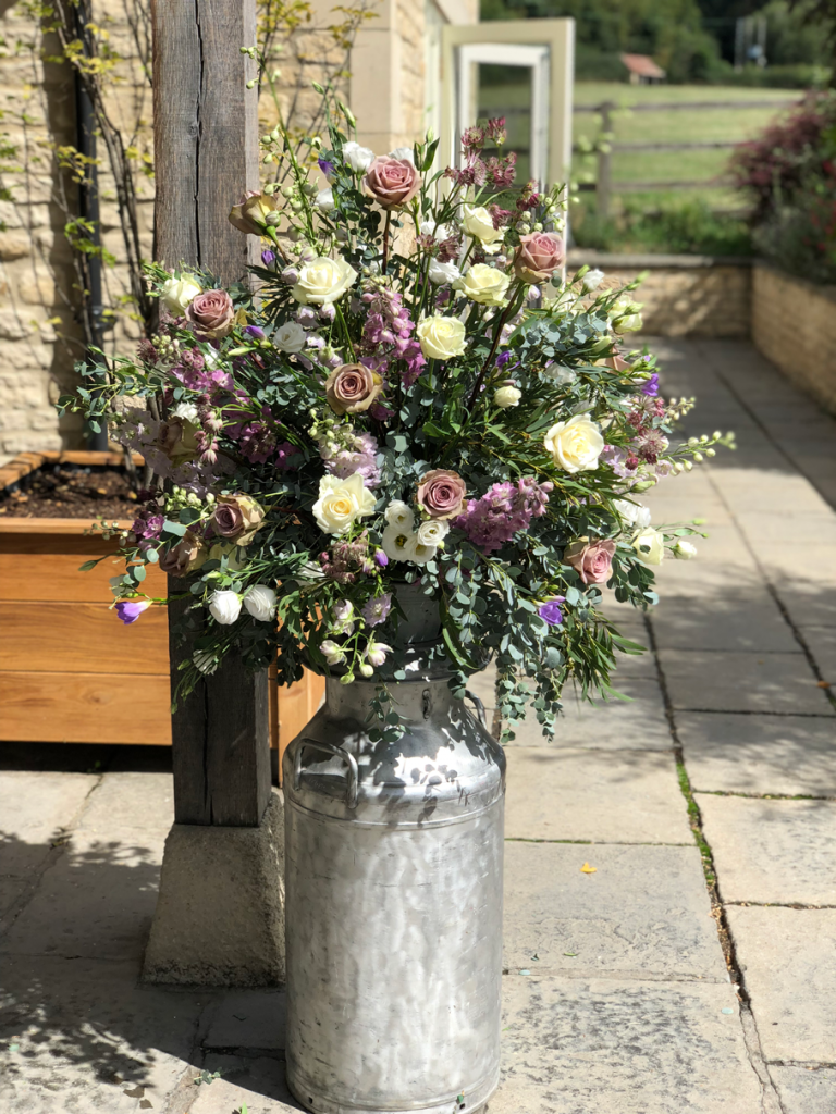 Amnesia and Avalanche roses with delphinium and eucalyptus outside Hyde House