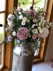 Milk churn with vintage pinks, and whites including allium, Hydrangea, Roses, and Astilbe. Floral design by Cotswold Blooms, wedding florist based in Cheltenham.