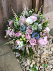 Light pink and light blue country garden display including Roses, Spray Rose and Nigella.  Floral design by Cotswold Blooms, wedding florist based in Cheltenham.