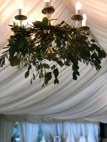 Foliage and Hypericum dressing the chandelier at Birtsmorton Court. Floral design by Cotswold Blooms, wedding florist based in Cheltenham.