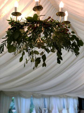 Mixed foliage and Hypericum dressing the chandelier at Birtsmorton Court. Floral design by Cotswold Blooms, wedding florist based in Cheltenham.