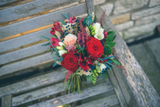 Textured hand tied bouquet in shades of red, white and blue with mixed foliage. Floral design by Cotswold Blooms, wedding florist based in Cheltenham.