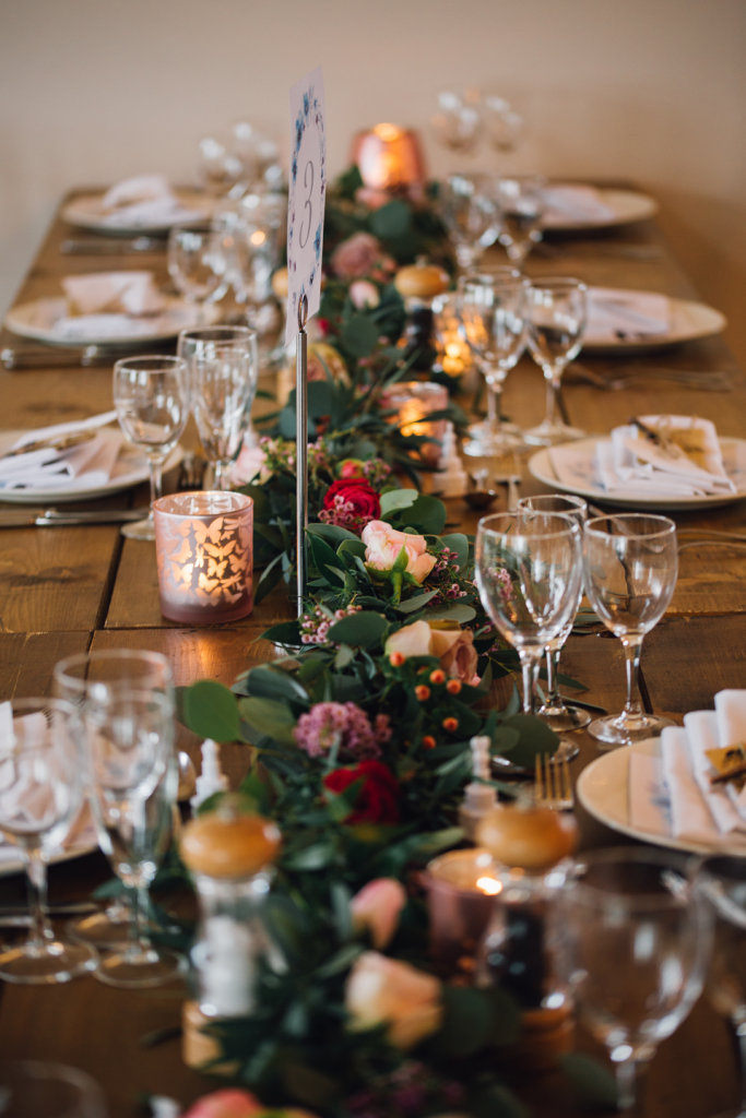 Textured trailing rustic table display with pops of red and pink