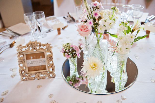 Vintage glass displays to dress top table. Floral design by Cotswold Blooms, wedding florist based in Cheltenham.