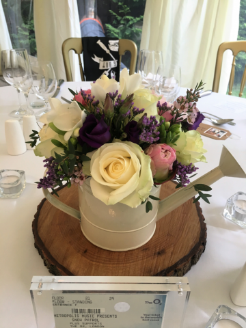 Peonies, Roses and Eustoma watering can table centre, at Birtsmorton Court. Floral design by Cotswold Blooms, wedding florist based in Cheltenham.