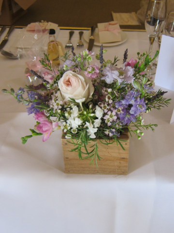 Box display filled with soft pastels in lilac, peach, white and pinks. Floral design by Cotswold Blooms, wedding florist based in Cheltenham.
